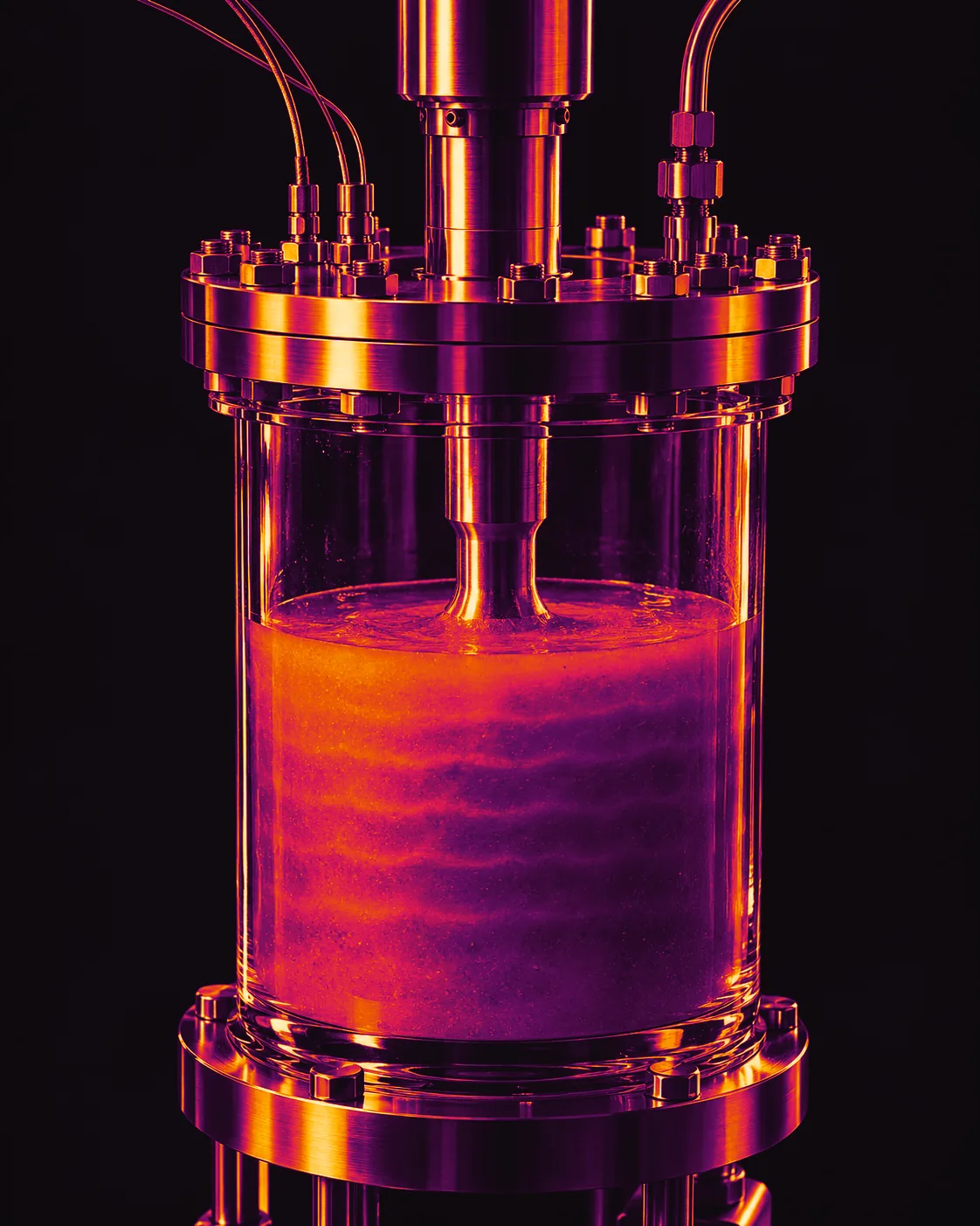 Illustrative image: a glass test cell under a steel flange, a sonotrode horn dipping into a glowing, layered suspension of metal and ceramic powders.
