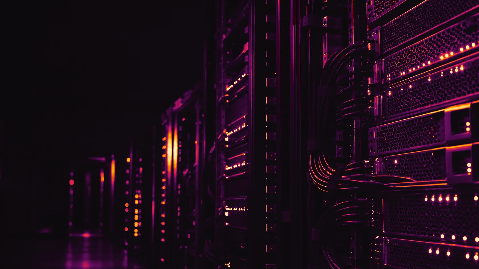 Bare-metal servers in a dark rack aisle: honeycomb front grilles, cable bundles and rows of status lights glowing amber and purple